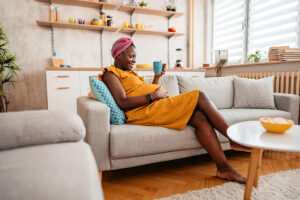 A young pregnant woman drinks tea