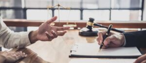 2 people sitting at a desk in lawyers office