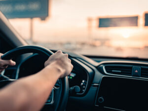 Hand of man driving car on the road