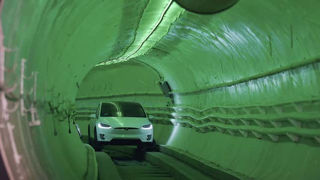 A photo of a Tesla driving through a Boring Company tunnel. 
