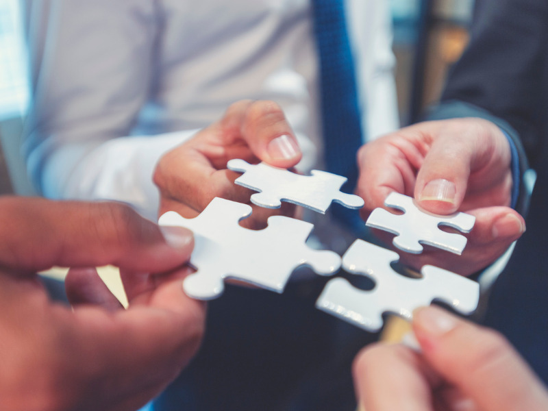 Group of businesspeople holding jigsaw puzzle pieces