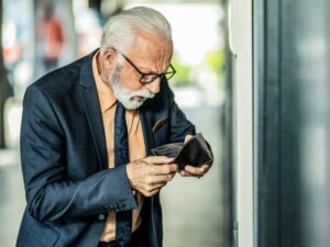 Older business person with empty wallet can't afford insurance