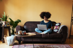 Mature woman sitting on couch using her laptop.