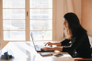 Brunette Woman Working On A Laptop In Her Home Office