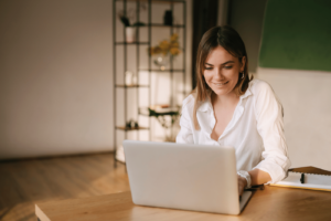 Happy Young Woman Working On A Laptop from home