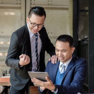 Businessmen looking happily at tablet