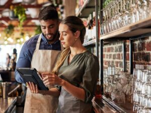 Restaurant manger and server consulting behind the bar