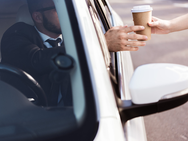 Driver being handed a coffee cup