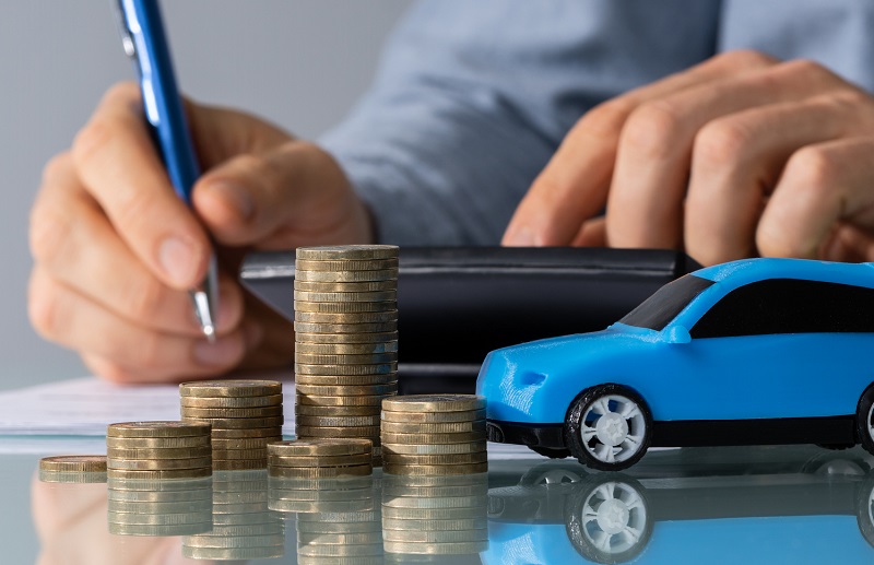 Blue Toy Car In Front Of Businessman calculating payments