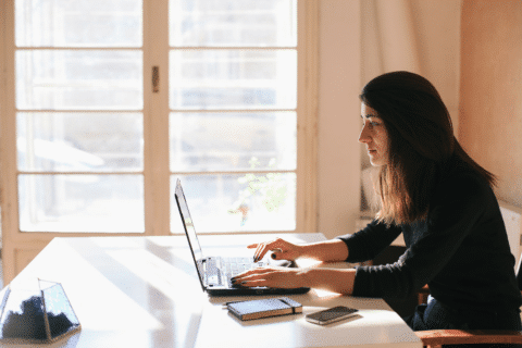 Brunette Woman Working On A Laptop In Her Home Office