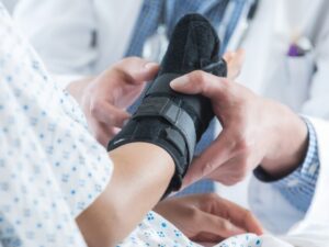 Doctor fitting a wrist brace after a sprain