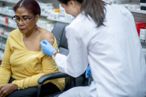 A woman is bandaged after having just received a vaccination in a pharmacy.