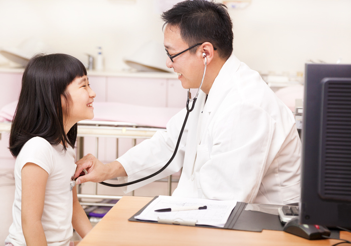Asian male pediatrician examining little Asian girl in a clinic Asian male pediatrician examining little girl