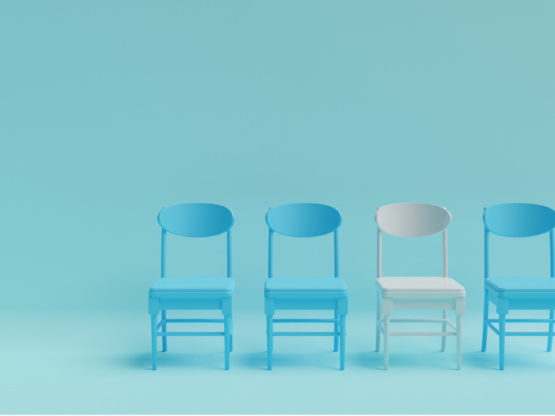 Four chairs side-by-side, three blue and one white