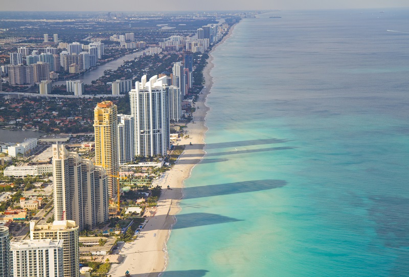 Aerial shot of Miami South Beach full of hotels with some long shadows reaching into the sea. Florida, USA.