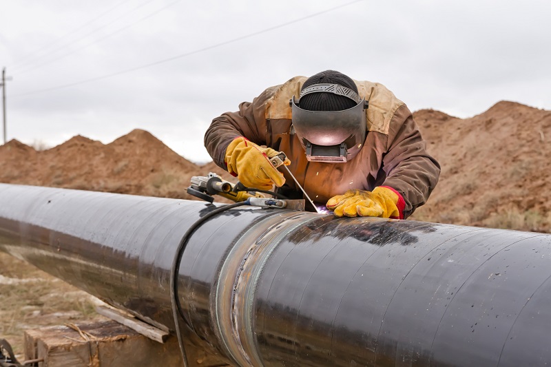 Welder works on gas pipeline