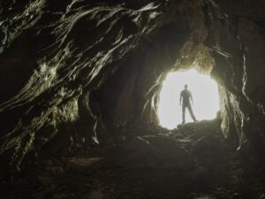 Person showing others the way out of a cave