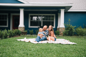 A young happy family on the lawn of their first home