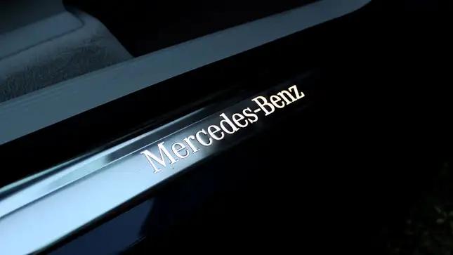 A photo of a Mercedes logo on the footwell of the car. 