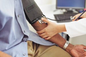 A photo of a doctor taking a patient's blood pressure.