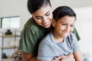 Mom gives son a hug in the living room