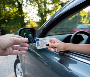 Driver handing license to police through car window