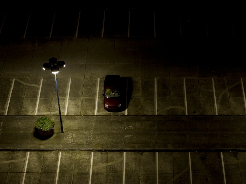a car alone in a dimly lit parking lot