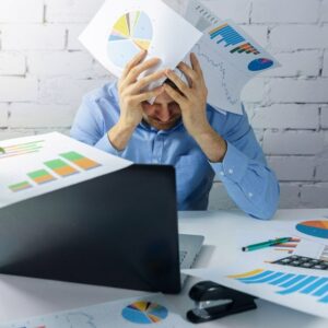 A worried businessman doing paperwork in office