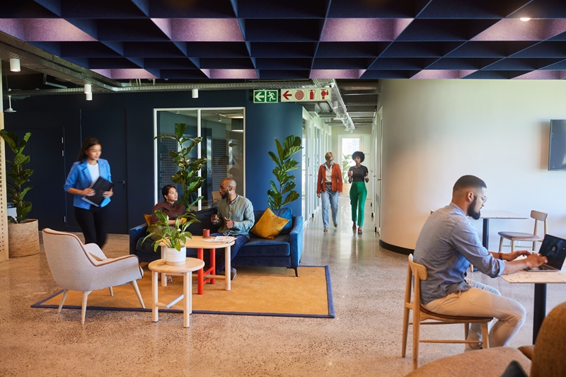 Diverse group of businesspeople busy working together in the lounge area of a modern hotel office space