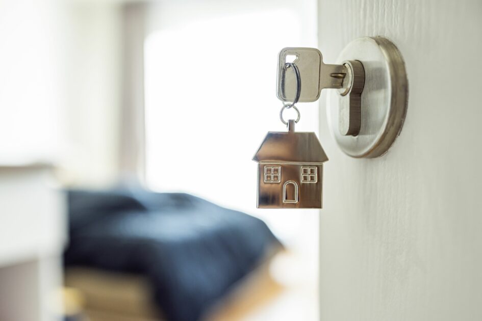 picture of a key in a door with a house keyring, the advantages of home insurance