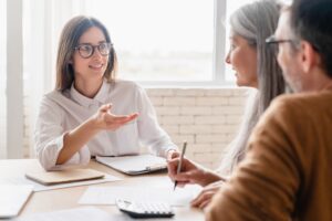 Insurance agent consulting mature, middle-aged couple signing contract documents at home