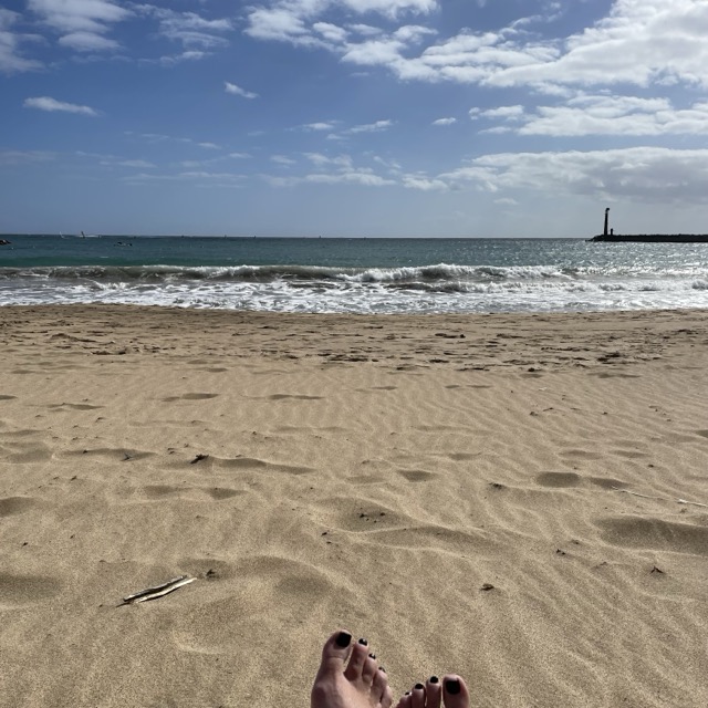 Feet on a a sandy beach with sea views lanzarote