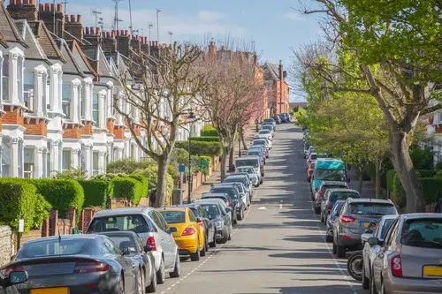 Cars parked along both sides of street in London.