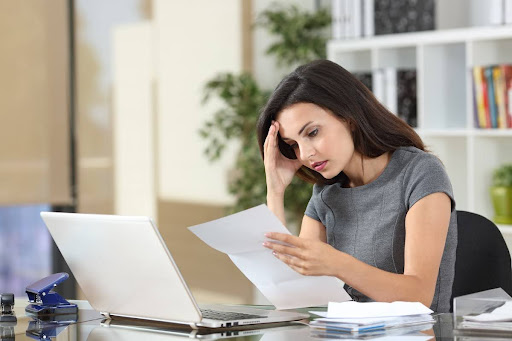 Frustrated woman reads paper to represent insurance claim being denied