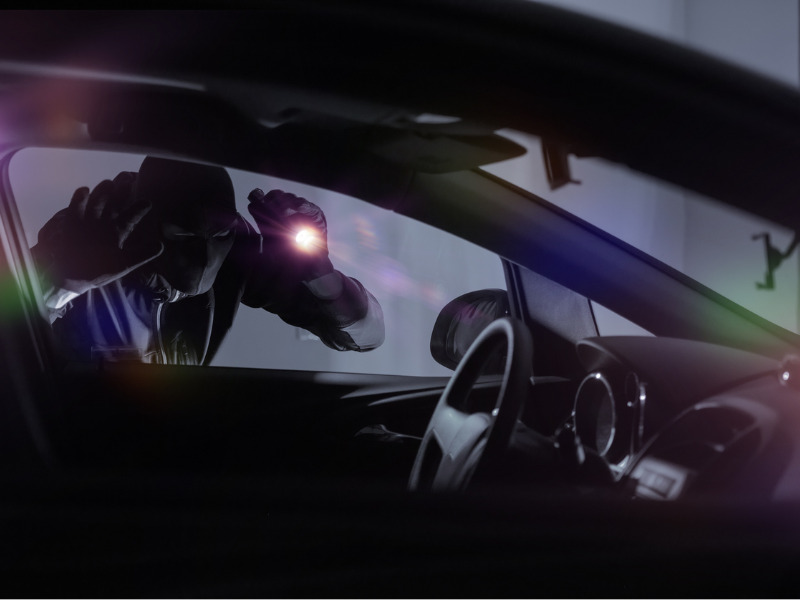 Car thief with flashlight