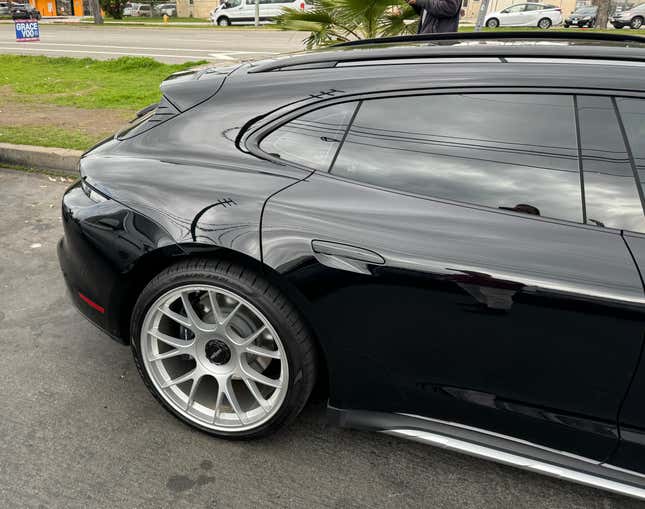 Rear wheel and door of a black Porsche Taycan Cross Turismo