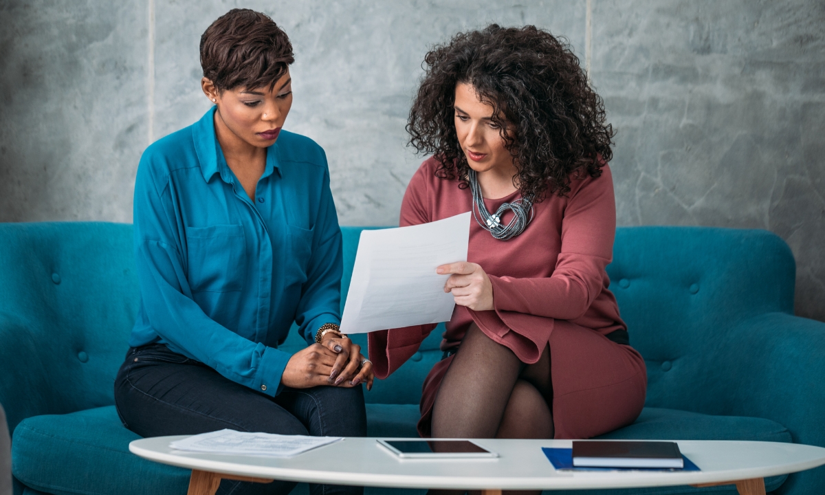 two women conversing over business matters on a couch