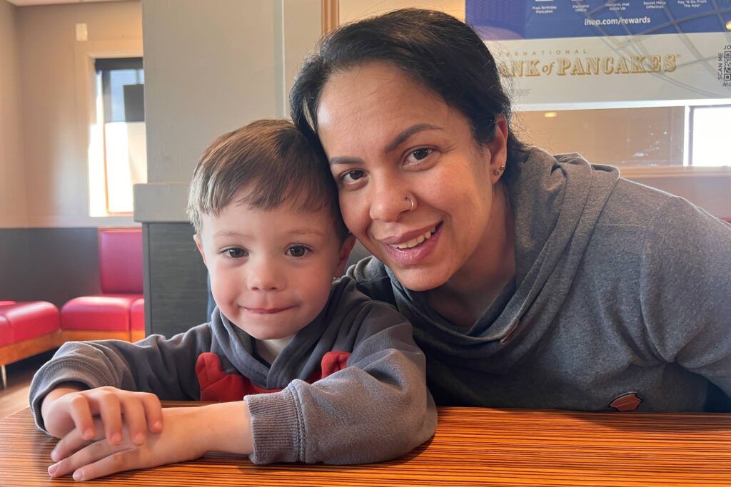 A photo of a mother sitting at a table with her young son.