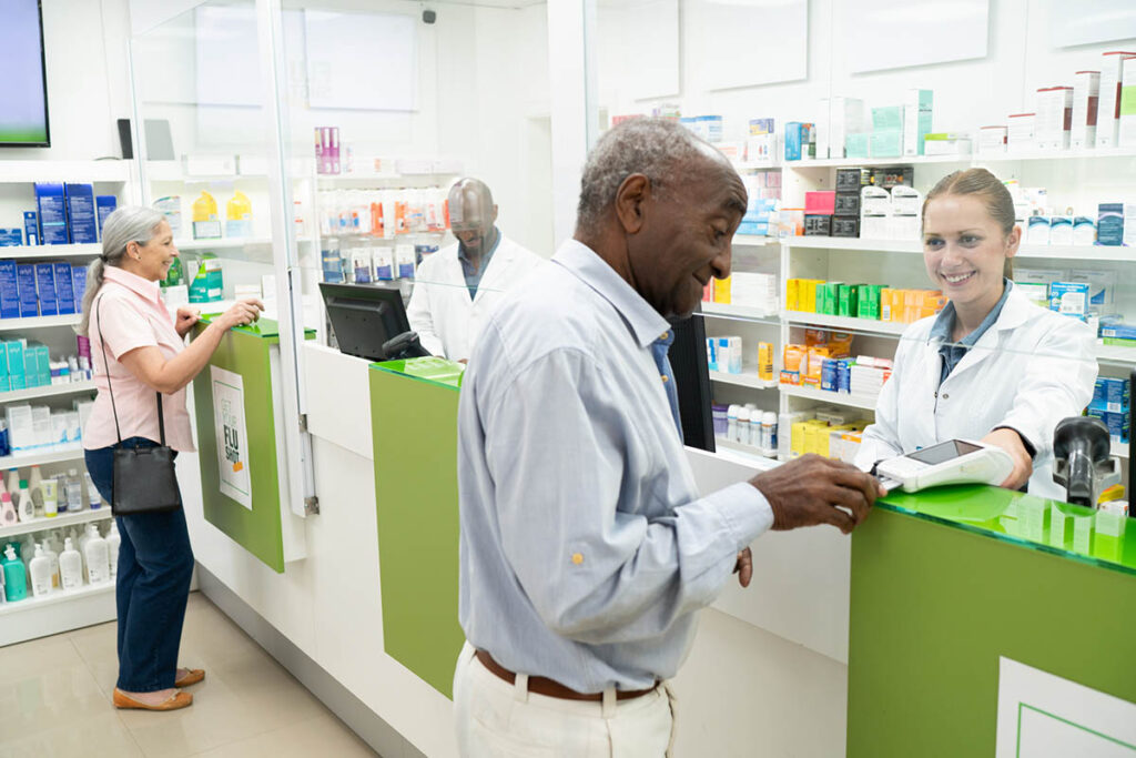 Senior man paying contactless at Pharmacy Checkout