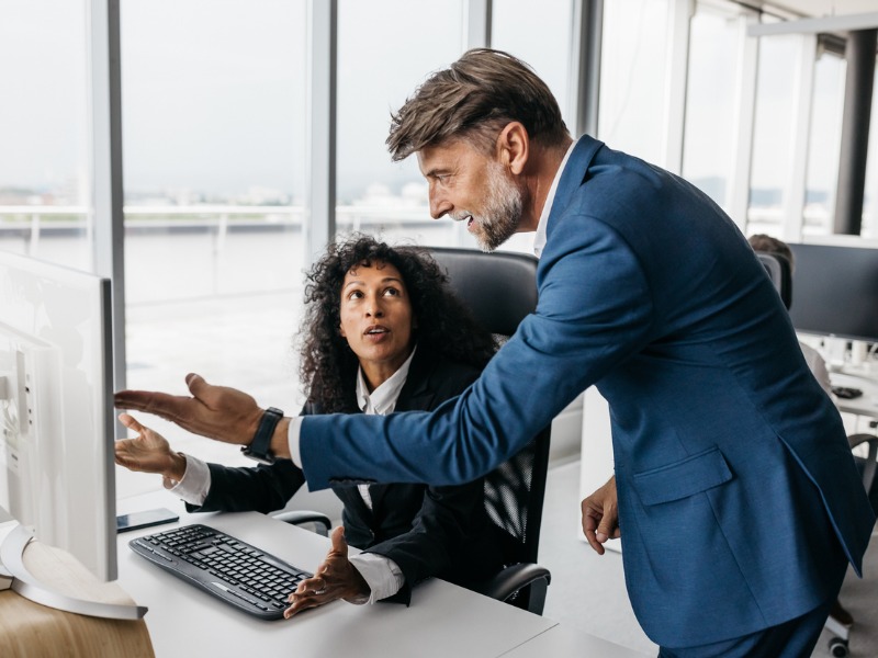 A smartly dressed business woman and businessman are having a heated discussion