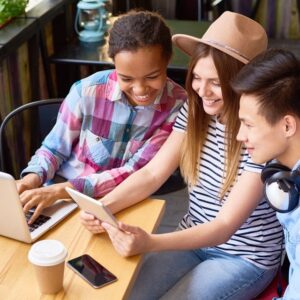 Friends sitting at a table looking at a laptop