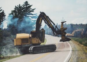 Forestry equipment is moved off a wildfire break in preparation for an airborne fire drop via helicopter.