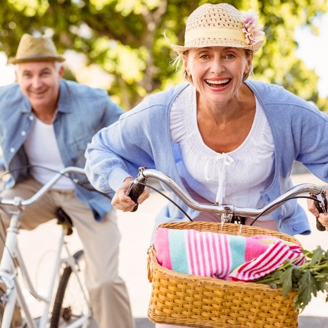 A happy older couple biking