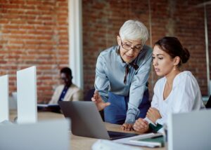 Older worker mentoring a younger colleague