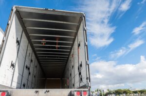 View of the inside of the rear of a huge empty freight truck with the rear doors open. Conceptual image of cargo theft