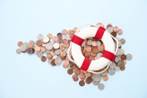 American currency beneath a lifebelt shot on a blue background.