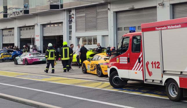 02 August 2024, Rhineland-Palatinate, Nürburg: Firefighters run in front of pit 27 in the pit lane of the Nürburgring.