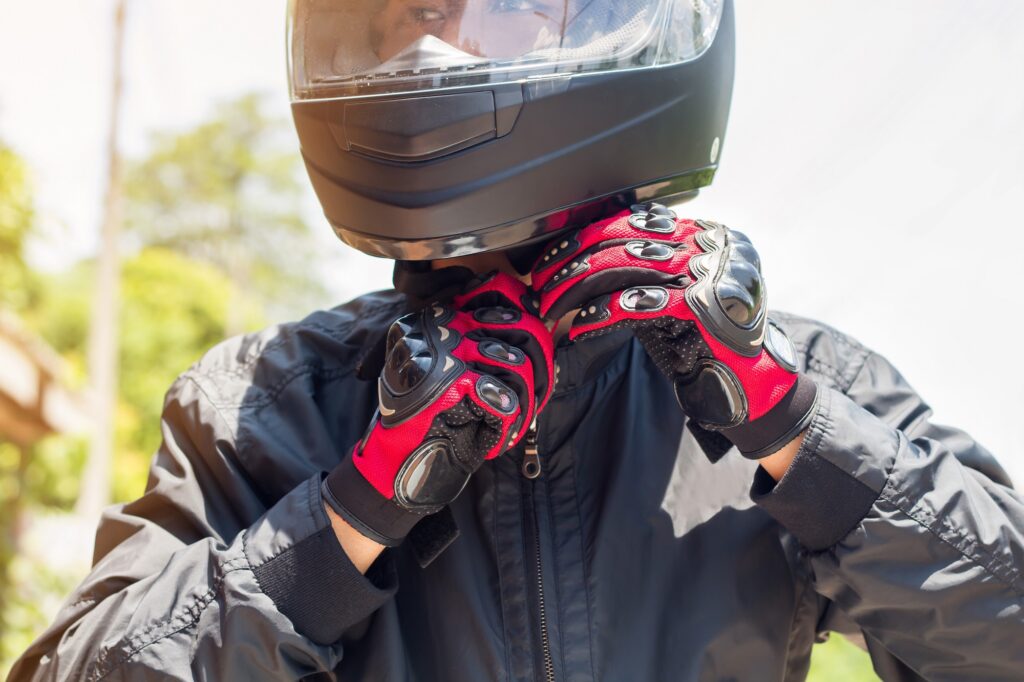 Man putting his helmet on, already kitted out with motorcycle gear