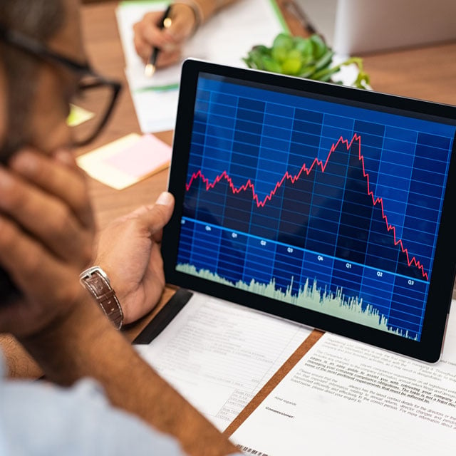 Worried man looking at stocks on a tablet