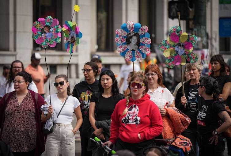 People seen in a march holding photographs of loved ones.